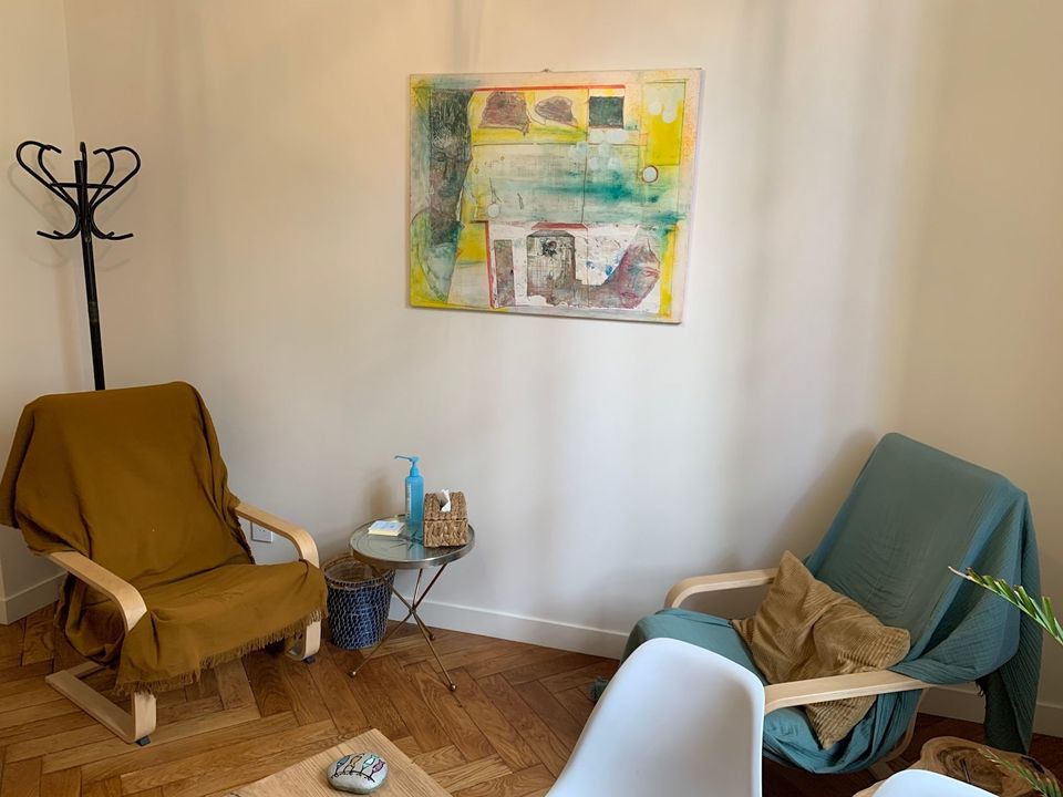 Salle de consultation avec deux fauteuils et un tableau coloré